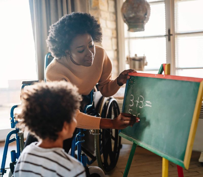 Little boy doing math exercises with her mother ot teacher together. Education people fun concept